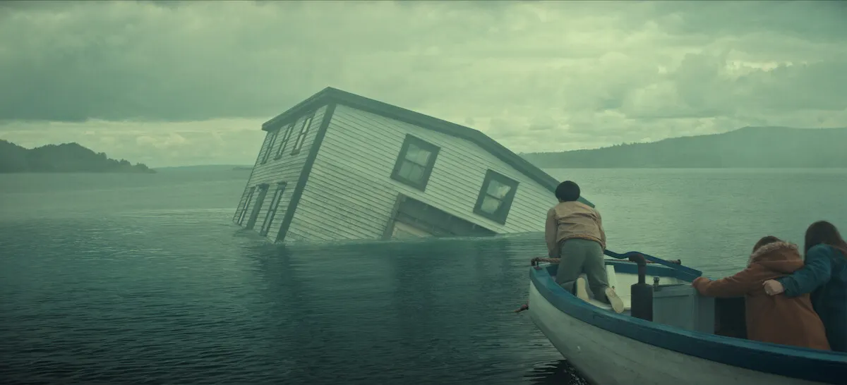 A house being towed across the water tilts dangerously in Below. Official promotional still: Jan Thijs / Netflix.